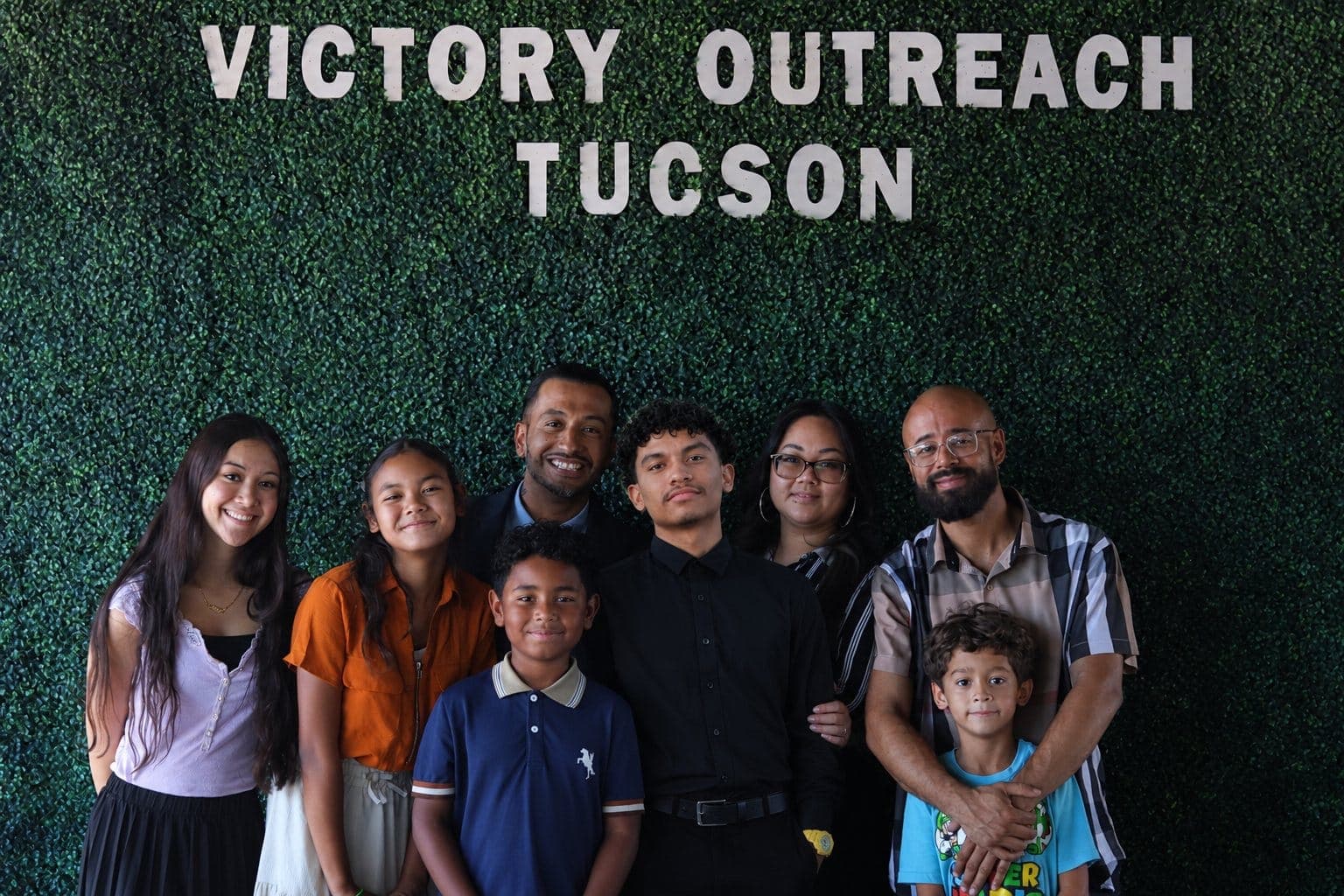 The Victory Mechanical family in front of the Victory Outreach Tucson sign