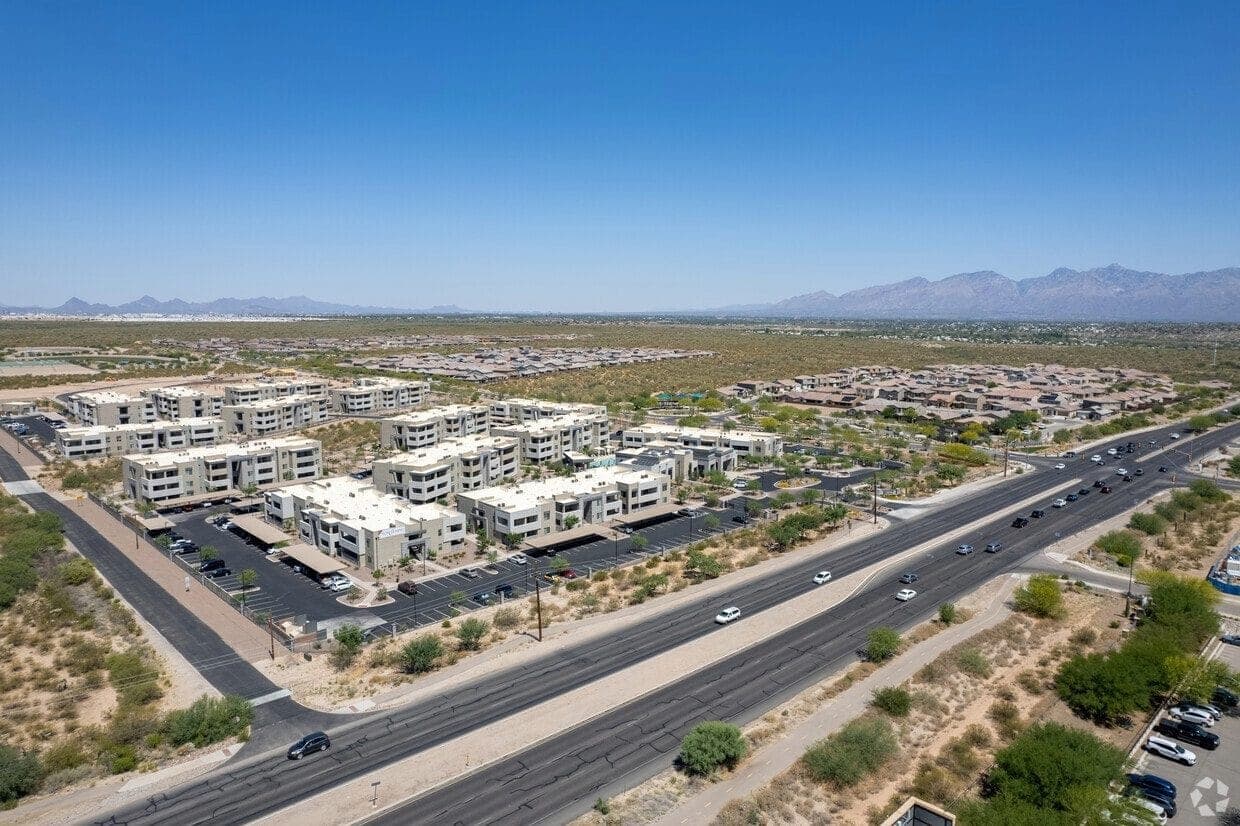 Aerial view of a Rita Ranch apartment community along a main road with mountains in the distance