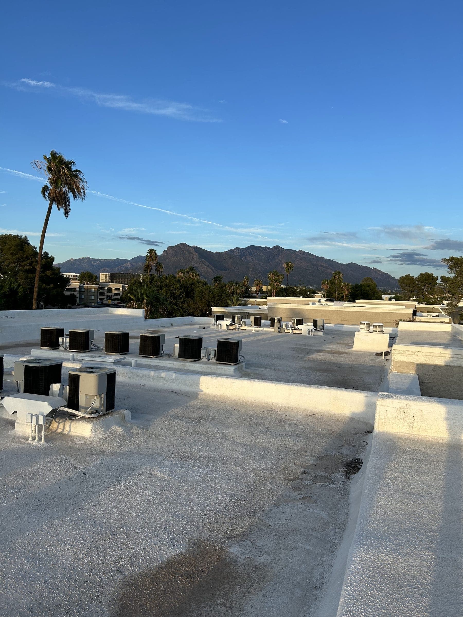 Rooftop condensers on a commercial building with mountains in the background
